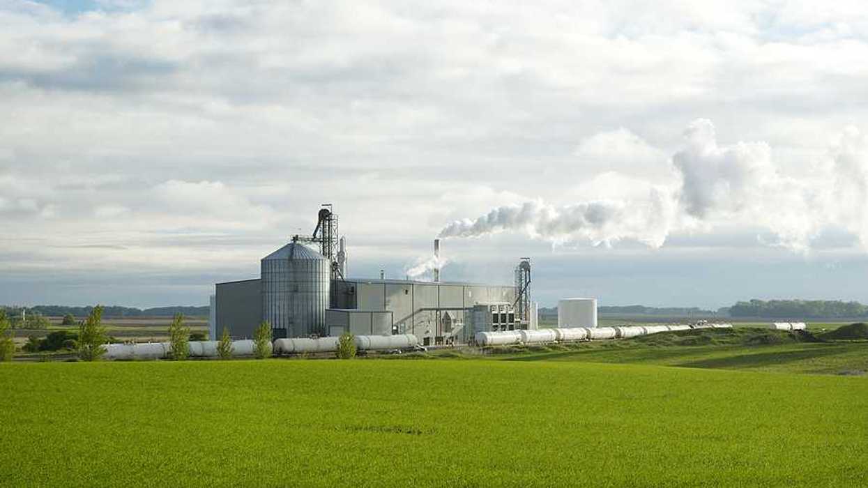 An ethanol plant with green fields in the foreground