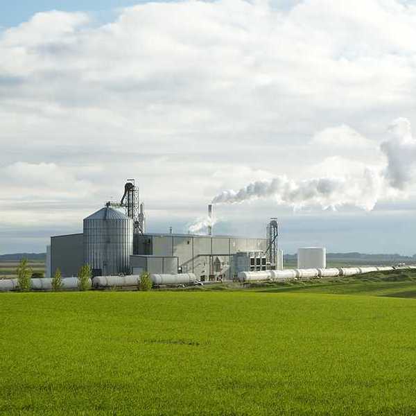 An ethanol plant with green fields in the foreground