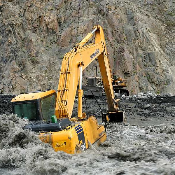 An excavator sitting on a flooded road in Pakistan