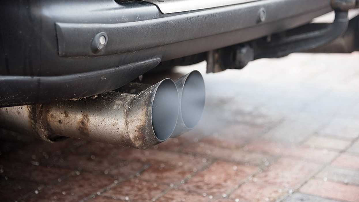 An exhaust pipe with smoke emitting from it.