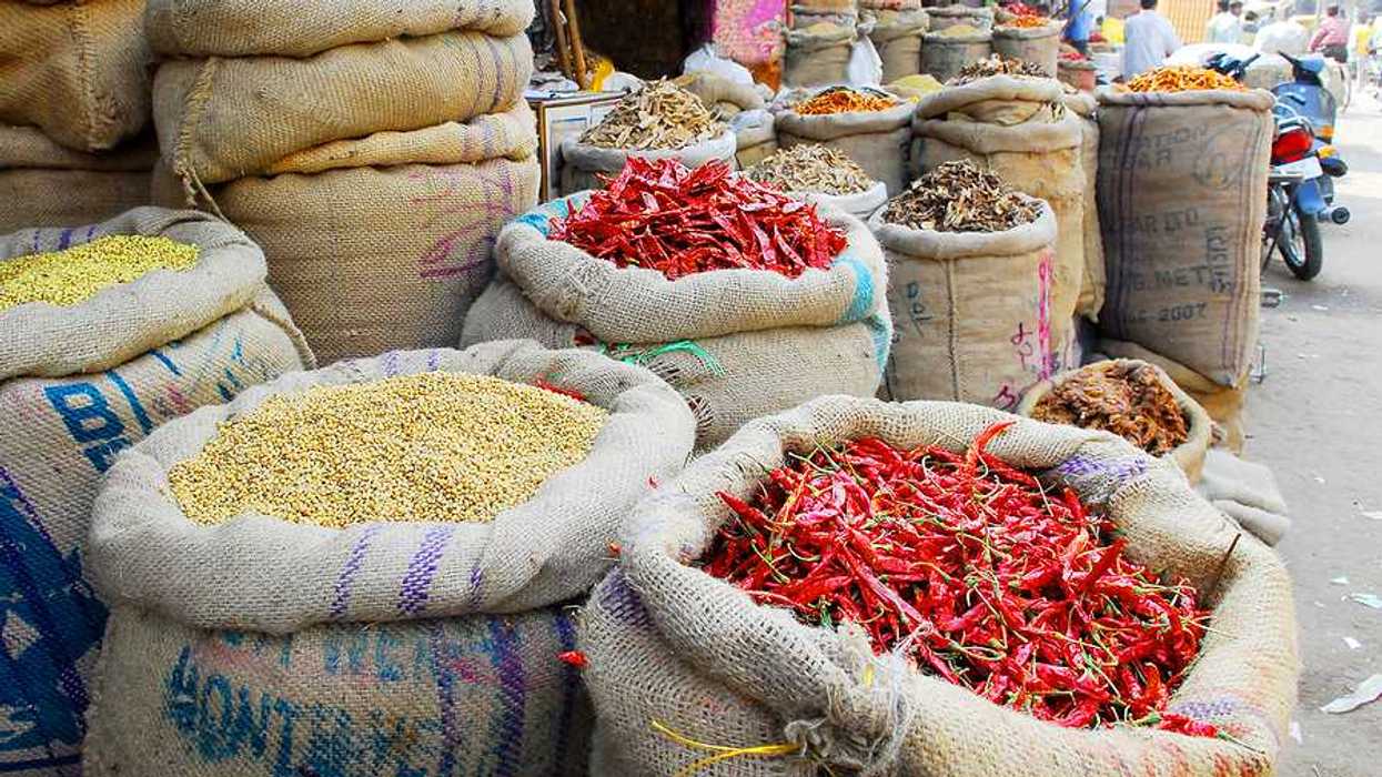 An Indian market with bags of spices and chilis