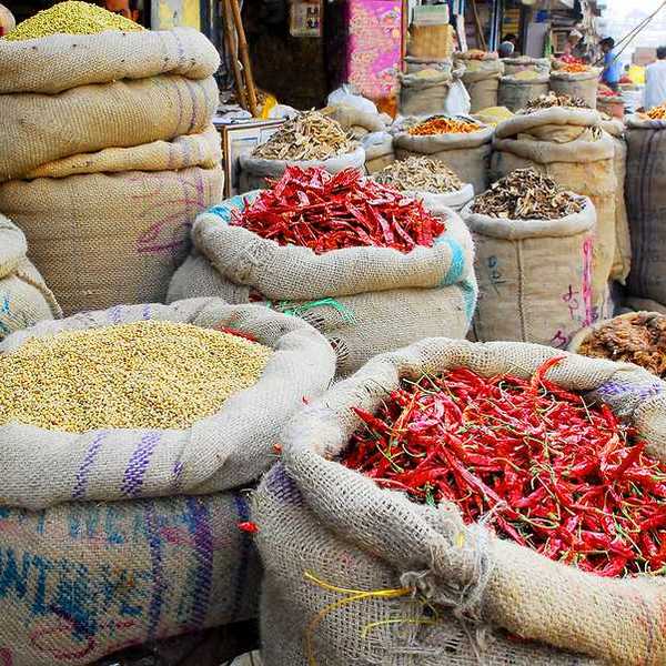 An Indian market with bags of spices and chilis