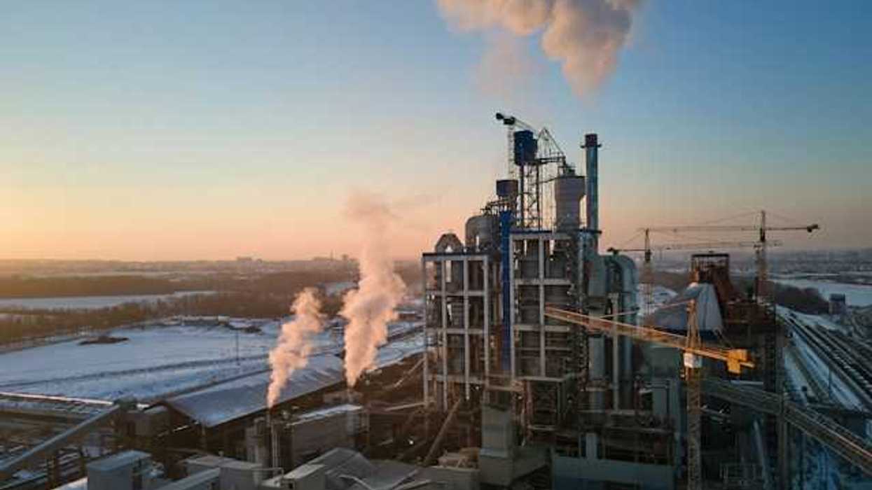 An industrial plant with cranes and smokestacks