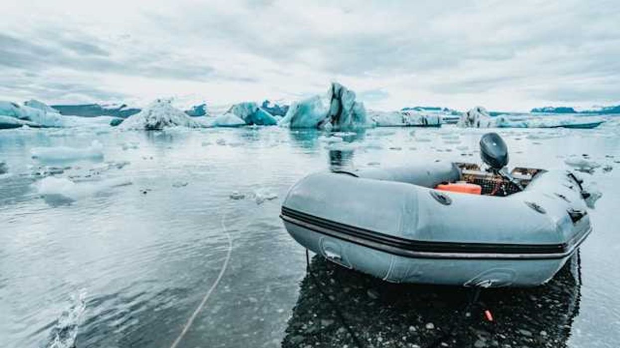 An inflatable boat pulled up to an icy shore