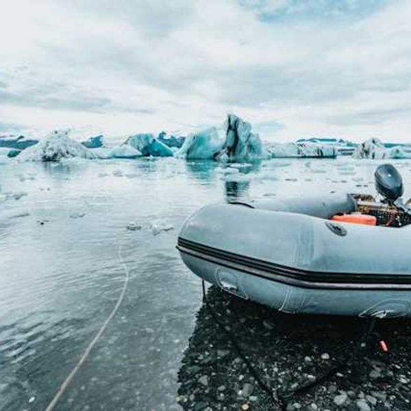An inflatable boat pulled up to an icy shore