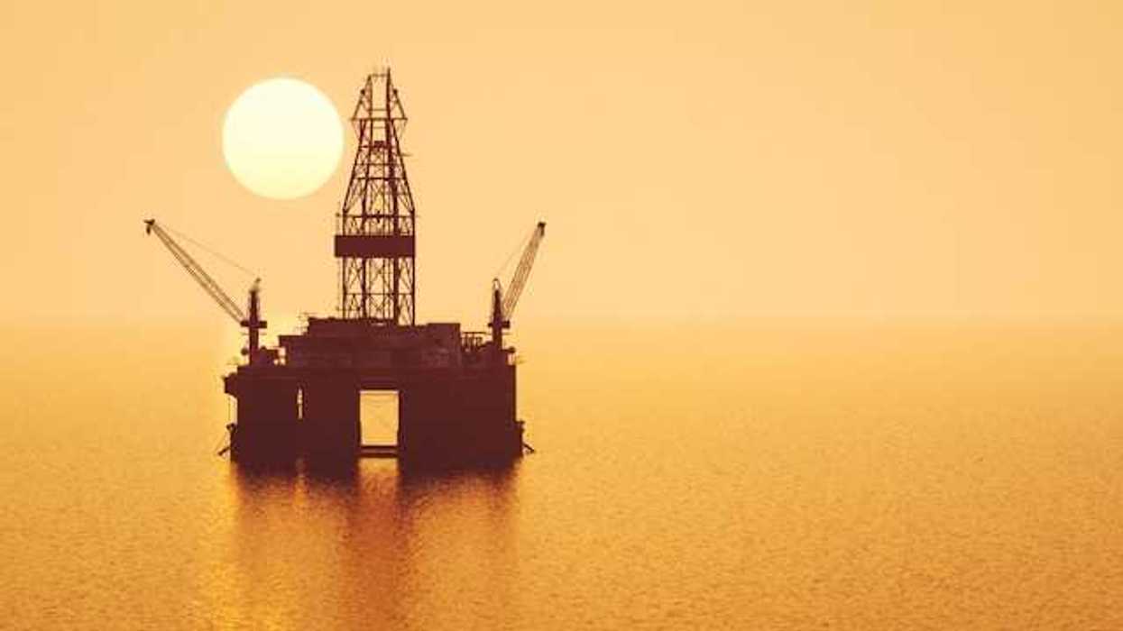 An offshore drilling platform with the setting sun in thedistance