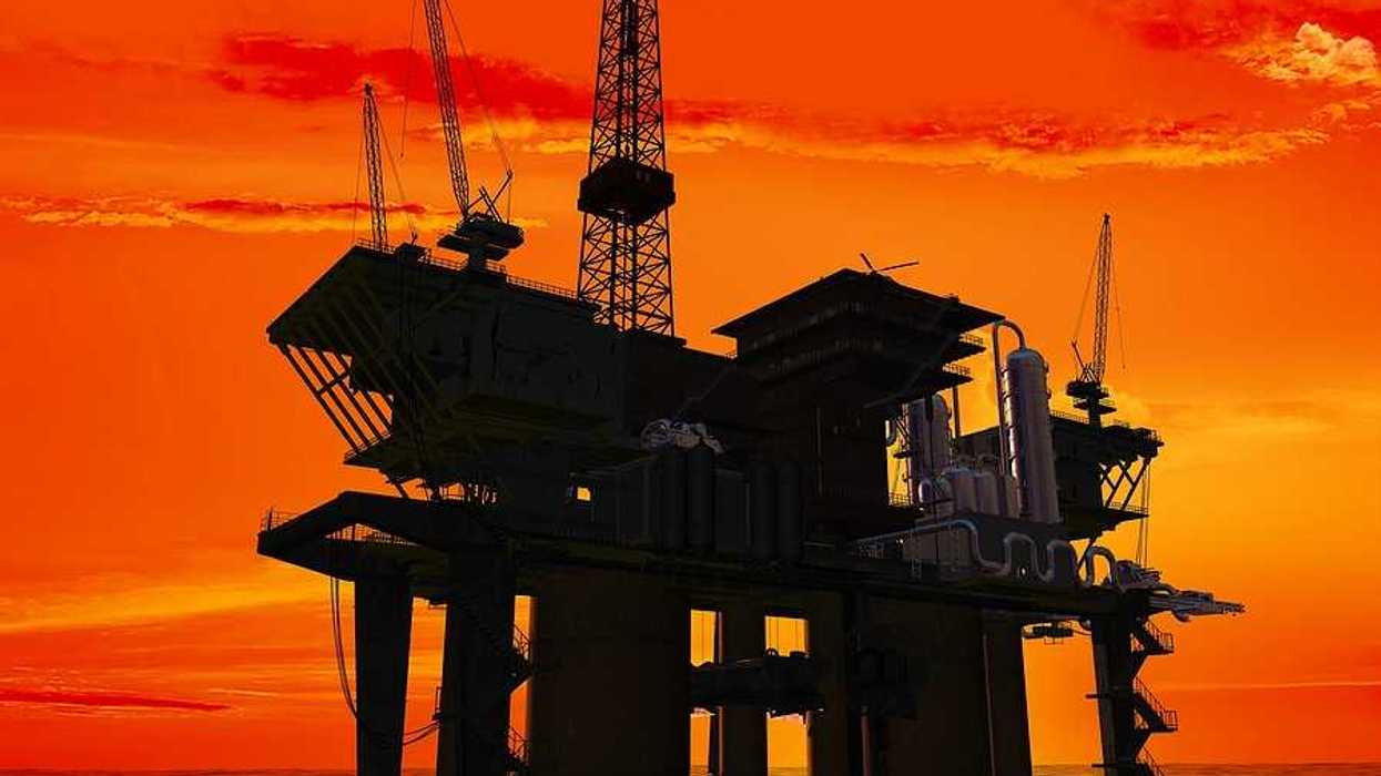 An offshore oil rig with the sunrise in the background