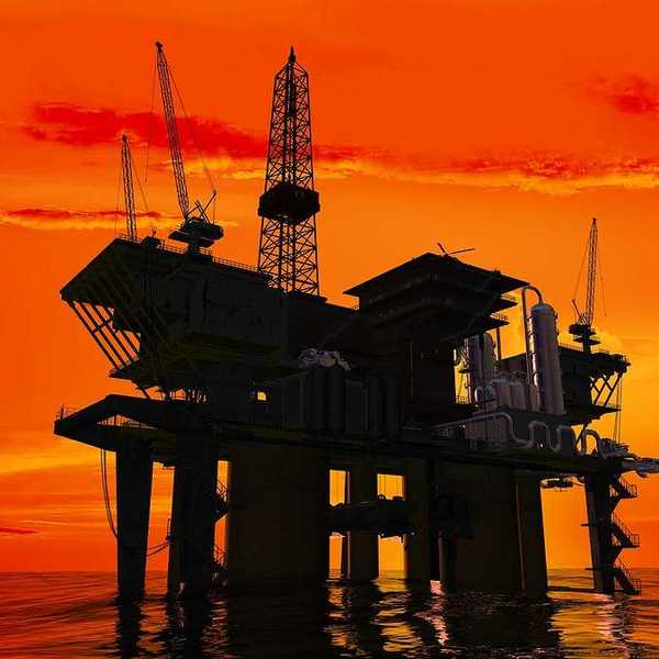 An offshore oil rig with the sunrise in the background
