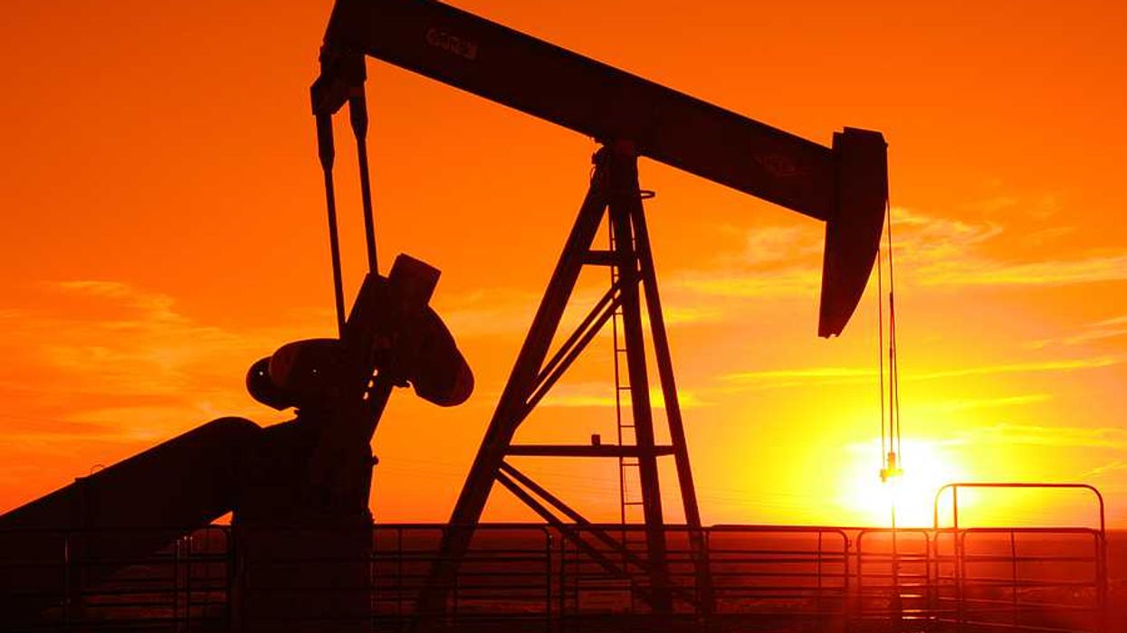 An oil drilling pump jack at sunset