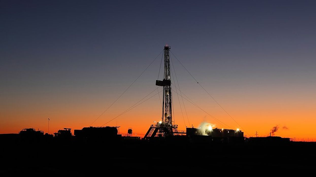 An oil well silhouetted against the sunset