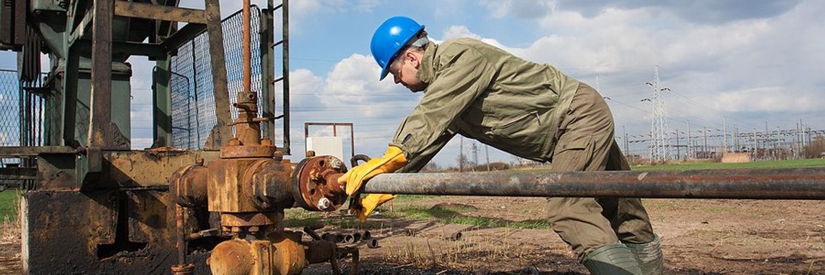 An oil worker using equipment to stop a leak.