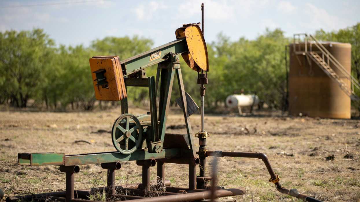 An old oil well pump jack in a field.