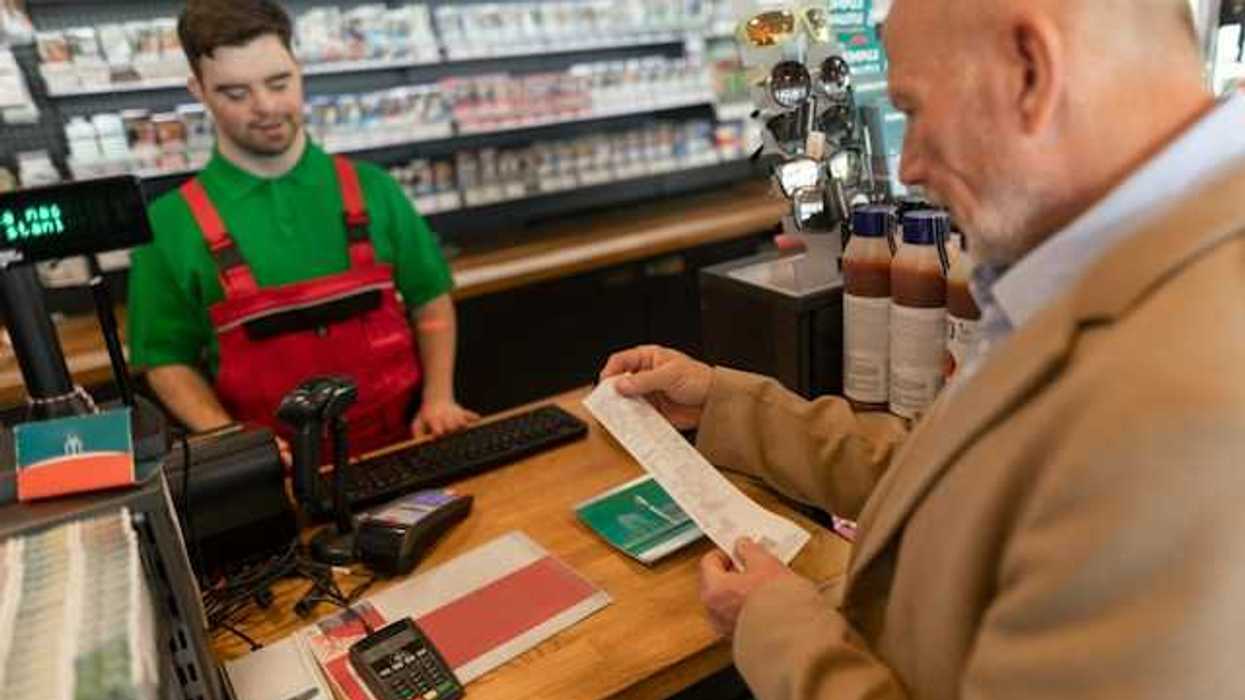 An older man looking at a store receipt