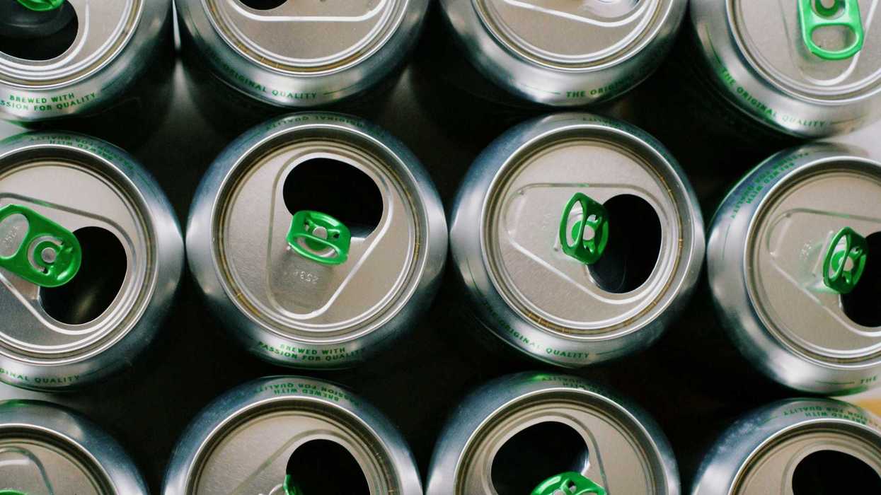 An overhead shot of a row of open canned drinks