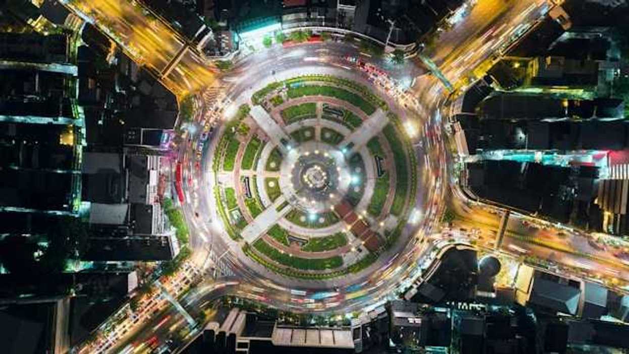 An overhead view of a city roundabout with a park in the middle