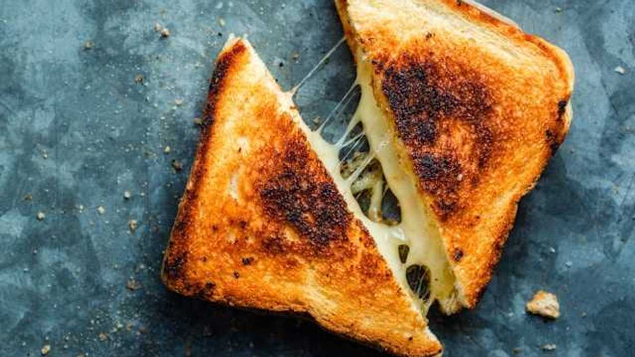 An overhead view of a grilled cheese sandwich on a green surface