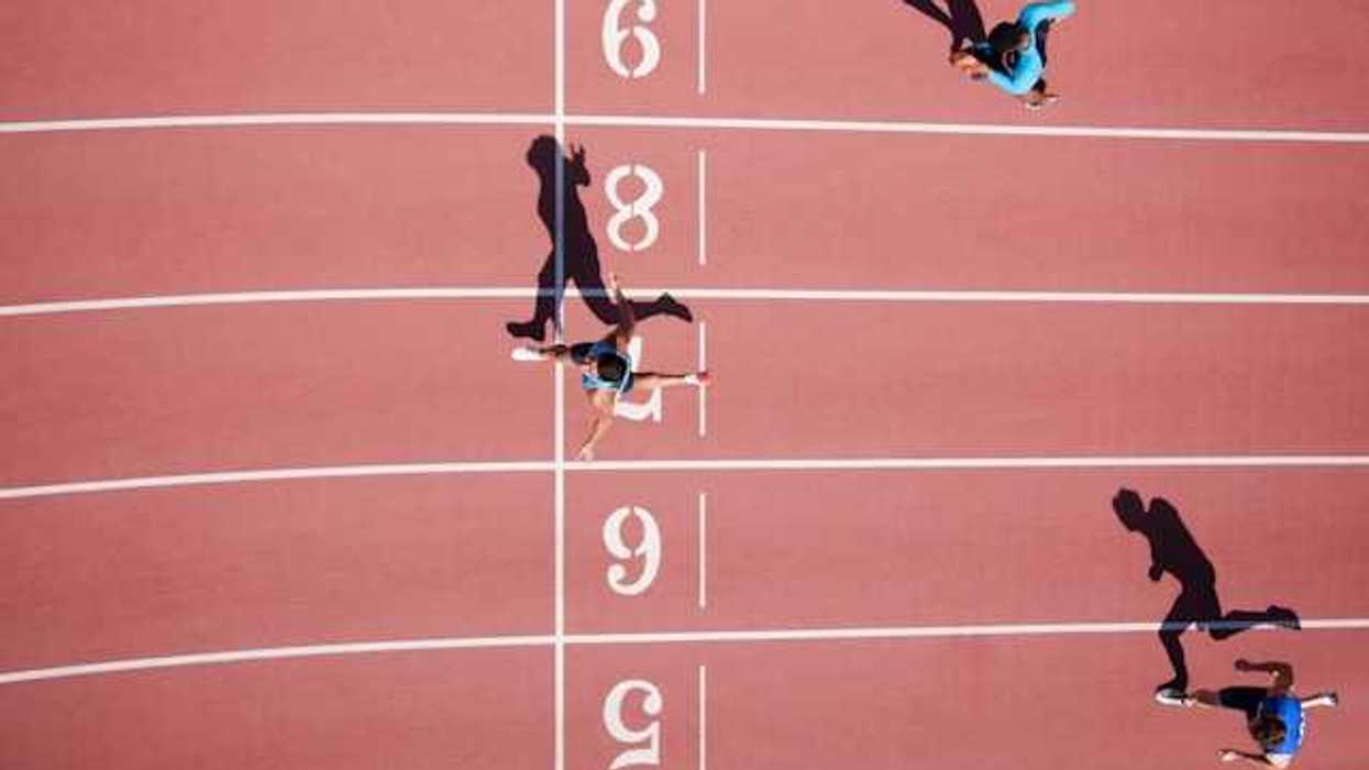 An overhead view of a running track with runners crossing the finish line