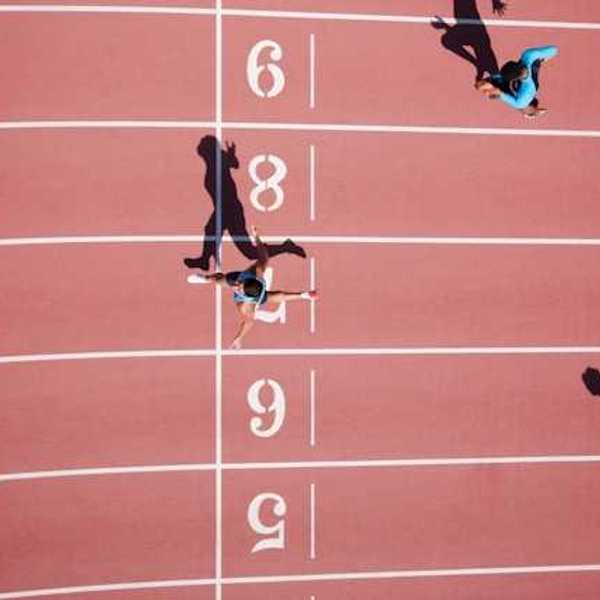 An overhead view of a running track with runners crossing the finish line