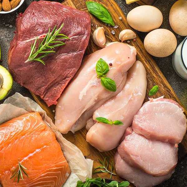 An overhead view of a table filled with meats, fish, poultry, and eggs