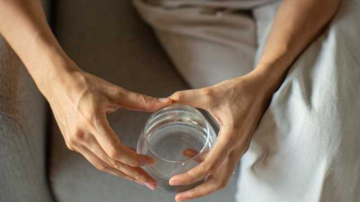 An overhead view of a woman holding a glass of water