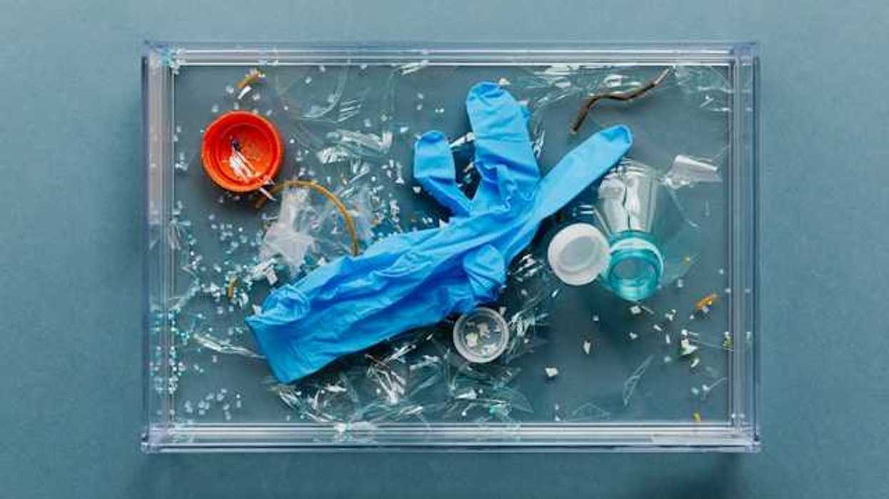 An overhead view of plastic medical gloves and other plastic materials in a plastic tray