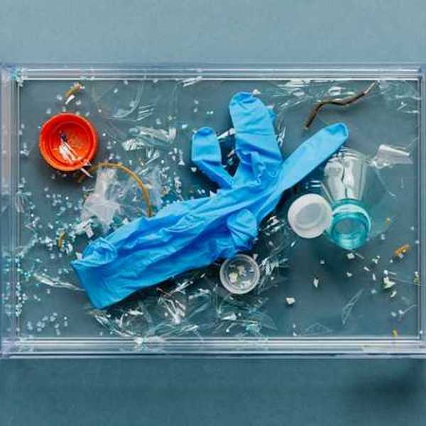 An overhead view of plastic medical gloves and other plastic materials in a plastic tray