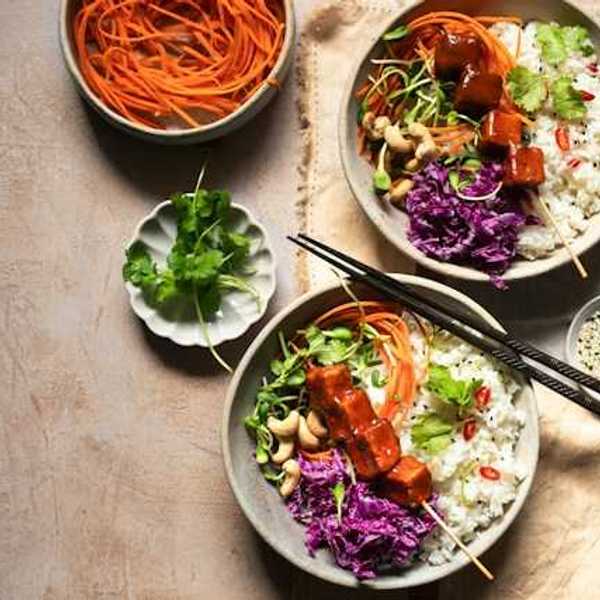 An overhead view of two rice and tofu bowls