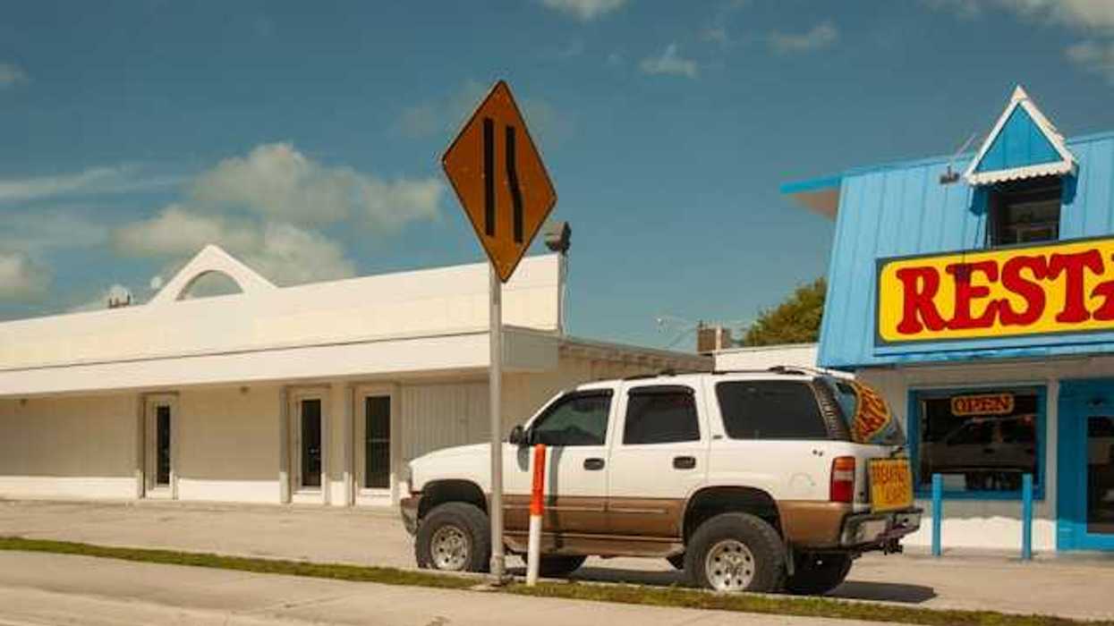 An SUV parked in front of a restaurant on a sunny day