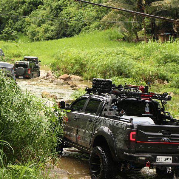 Armed vehicles drive through a river.