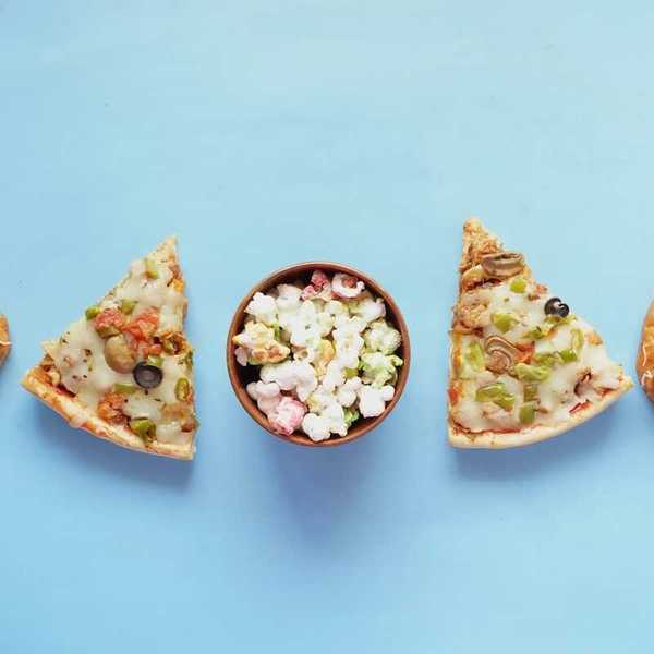array of unhealthy ultraprocessed foods: pizza, jelly donuts, popcorn
