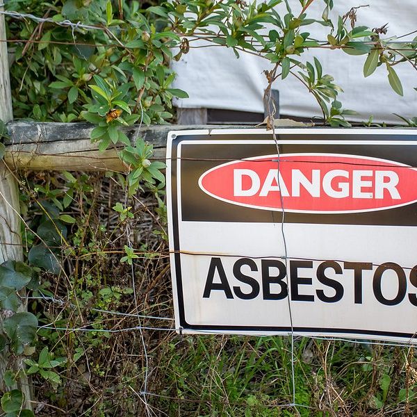 Asbestos danger sign on a fence.