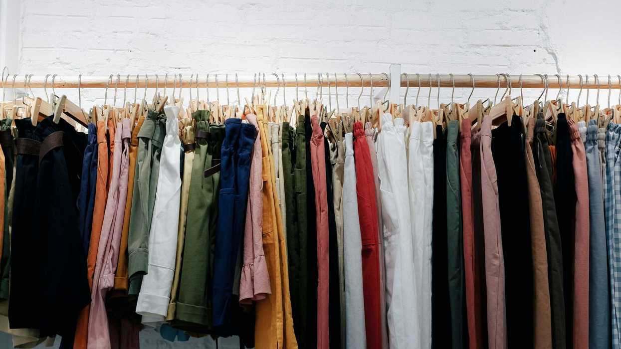 assorted-color clothes lot hanging on wooden wall rack.