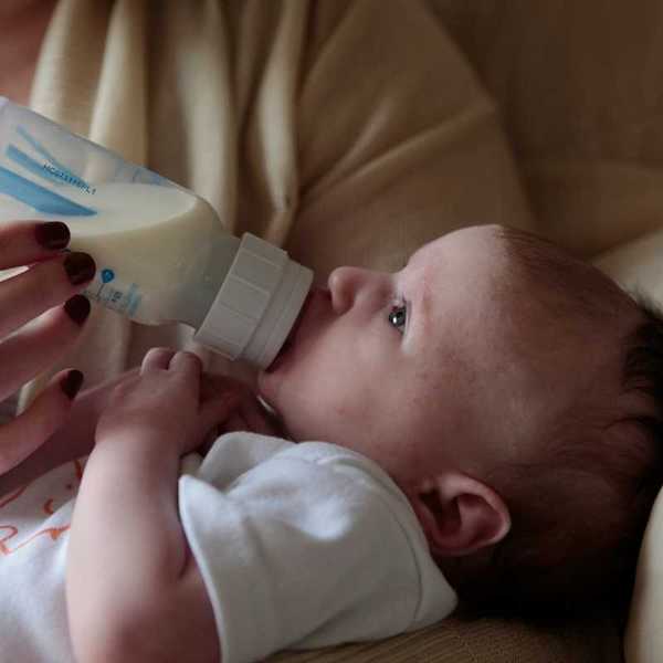 Baby being bottle-fed from plastic bottle