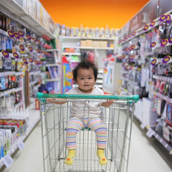 baby in supermarket cart aisle