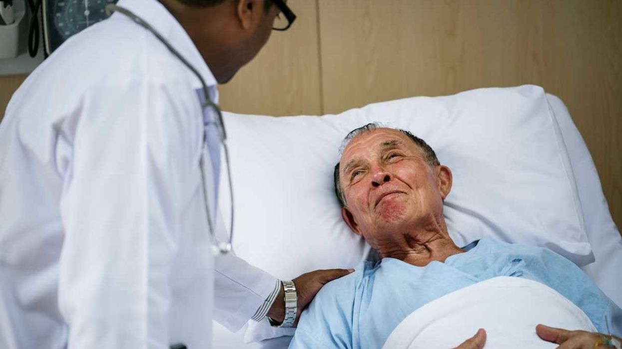 Bedridden elderly male with doctor