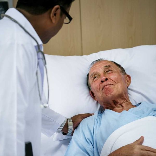 Bedridden elderly male with doctor
