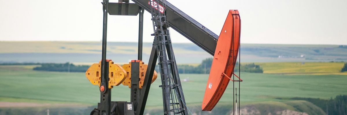 black and orange oil pump jack on green grass field during daytime