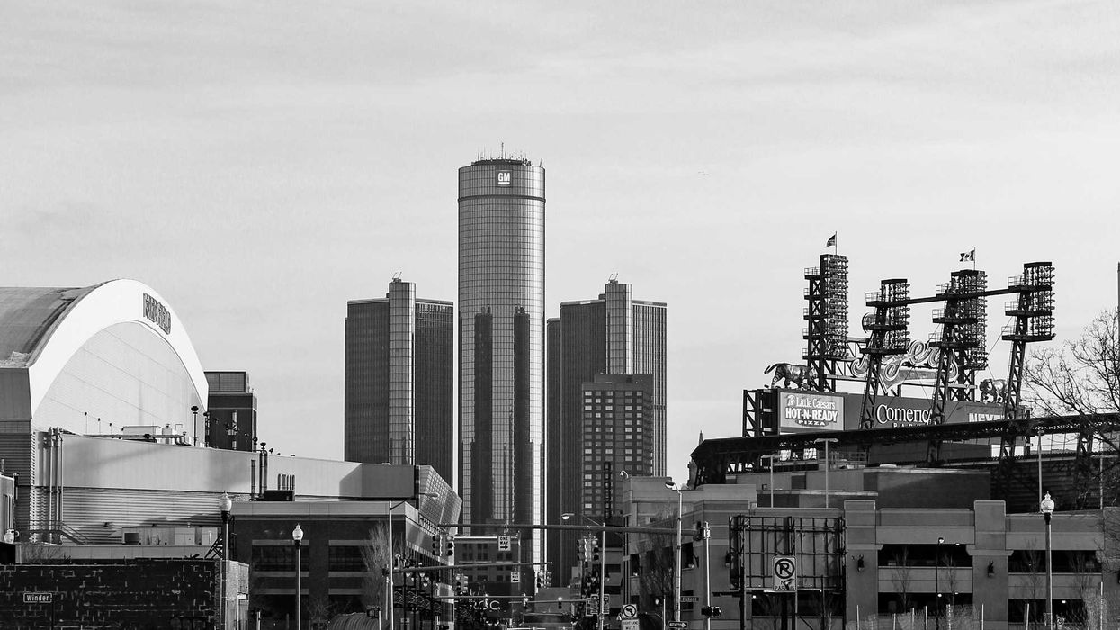 Black and white photo of a snowy street with city buildings in the background