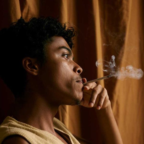 Black man smoking hand-rolled tobacco cigarette