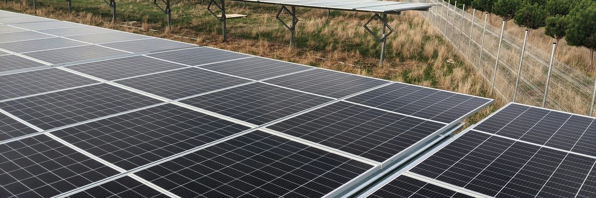 black solar panel on green grass field during daytime.