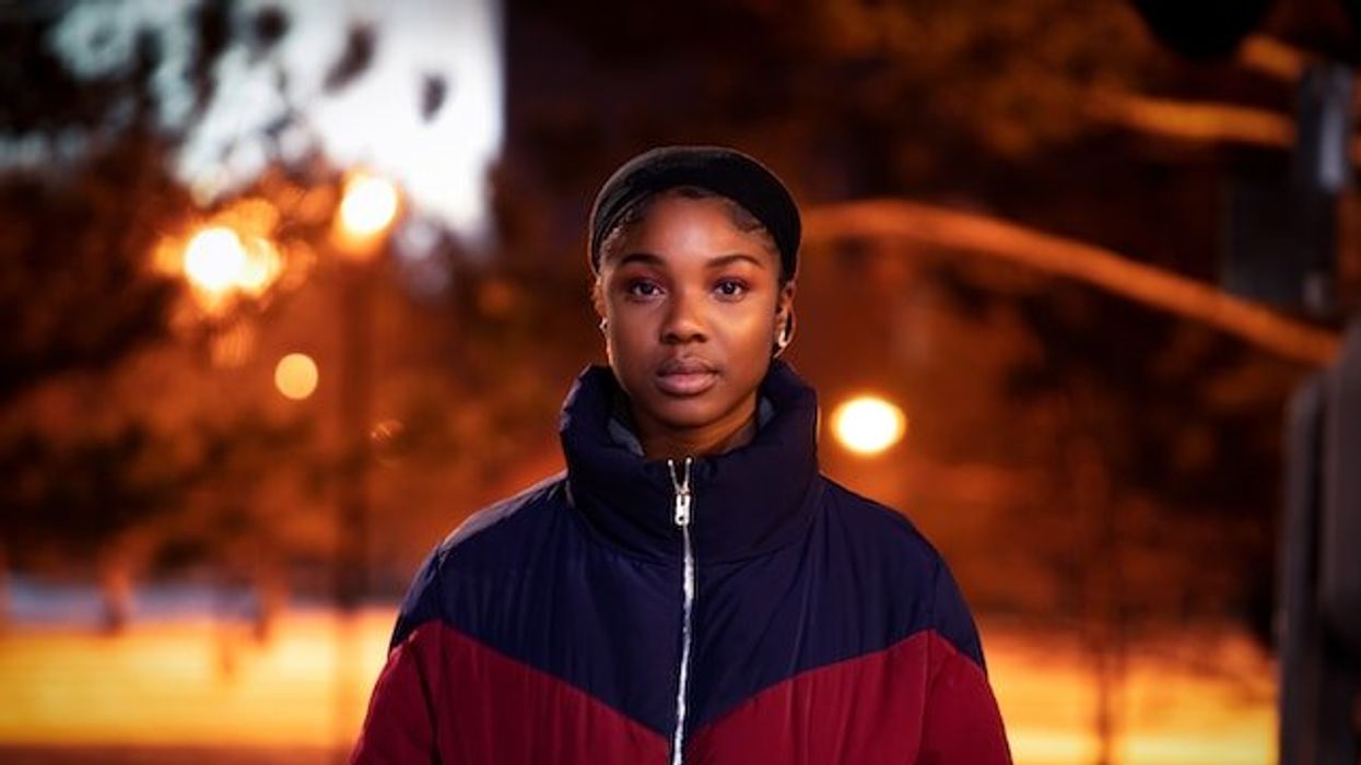Black woman standing in the street at night
