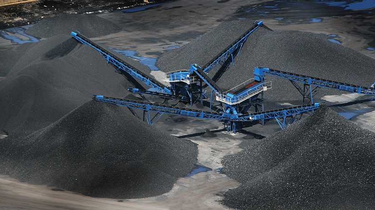 Blue cranes placing coal onto large piles
