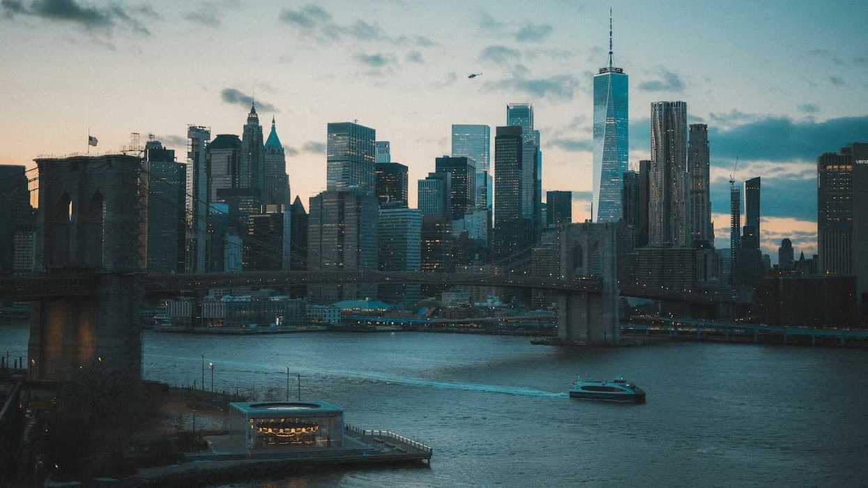 Boat traveling on a NYC waterway with Manhatten skyline in background
