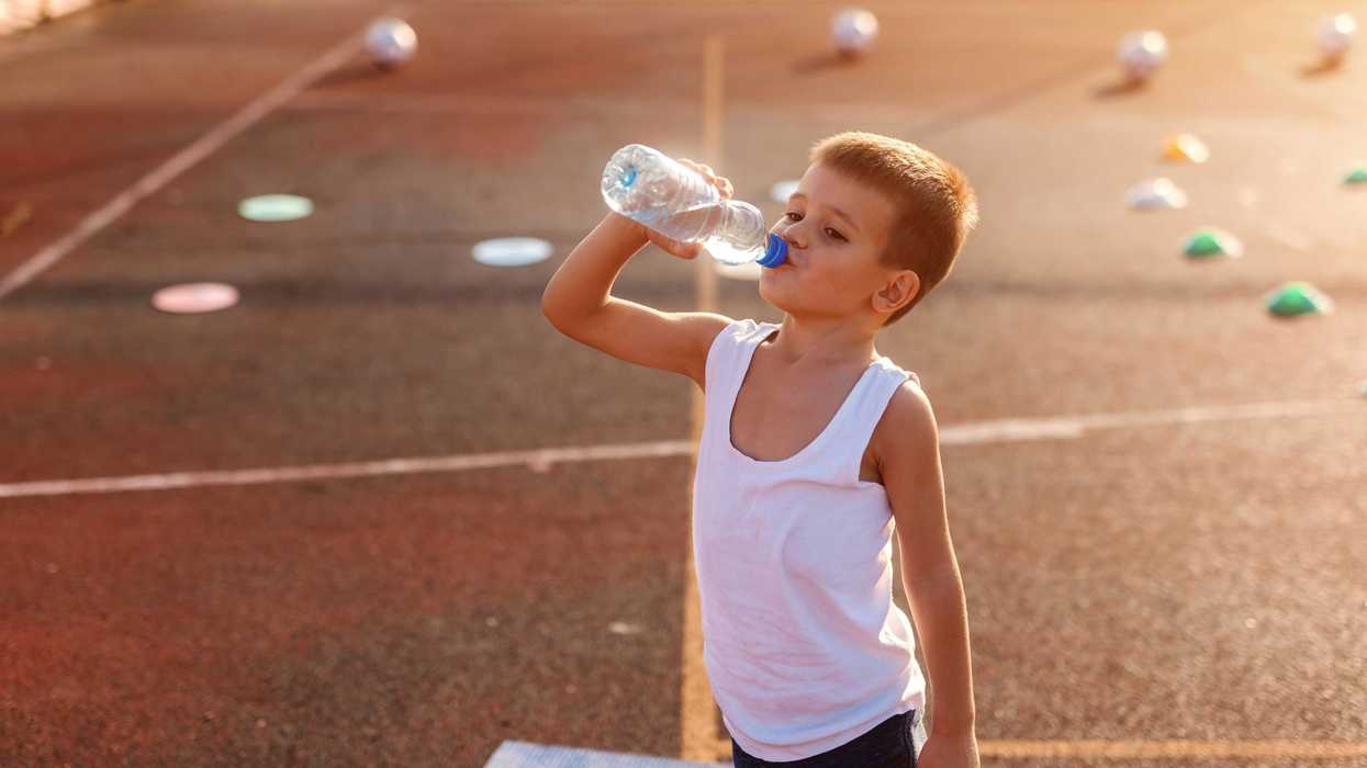 boy drinking from plastic water bottle