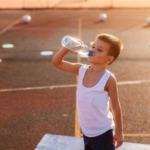 boy drinking from plastic water bottle