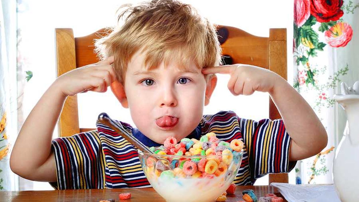 Boy eating multi-colored cereal  at a table