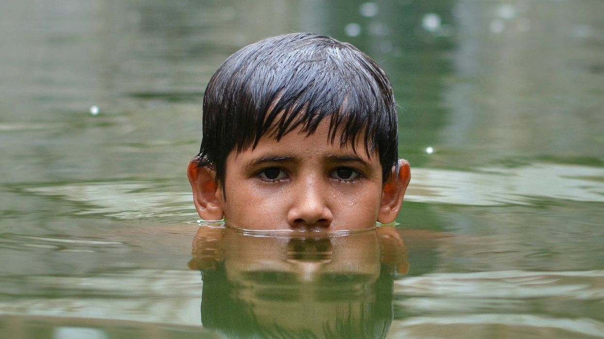 Boy immersed up to nose in floodwaters