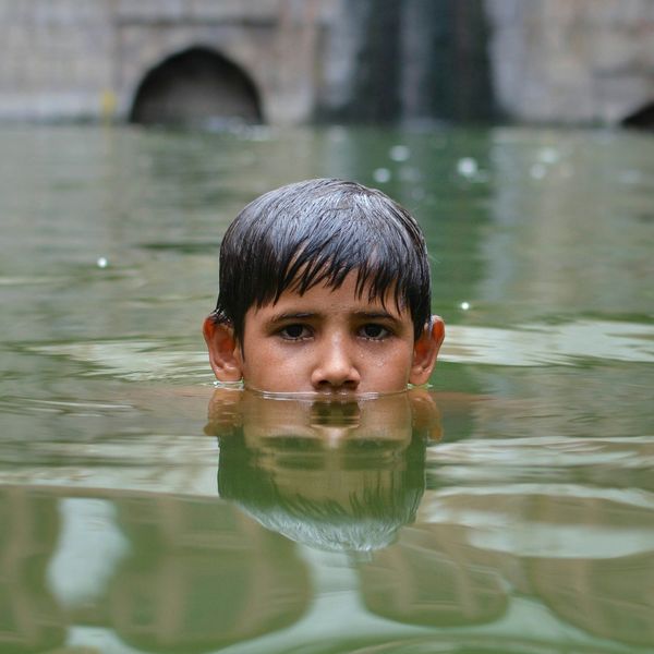 Boy immersed up to nose in floodwaters