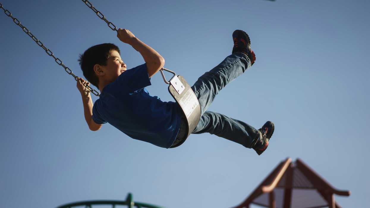 Boy on a swingset in a playground