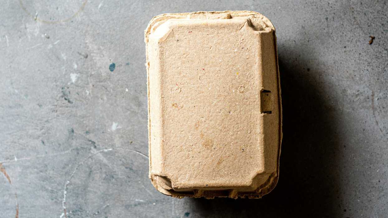 Brown biodegradable food container on a gray surface.